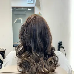 A beautiful hair color transformation styled into deep, glossy waves. The highlights are blended to create dimension and movement from the back.