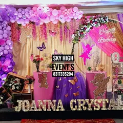 An "Angel theme" for Joanna Crystal's first birthday, filled with shades of purple and pink. The decor includes fairy and angel silhouettes, butterfly accents, and a floral arch.