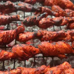 The heart of our cooking is in traditional techniques. Here, our chicken tangdi kababs are grilled over charcoal, giving them an authentic smoky flavor that you can't get from an oven.