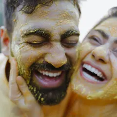 Pure, unadulterated joy. We believe the best moments are the unscripted ones, like this candid laugh during a Haldi ceremony, where love is smeared on with turmeric and happiness.