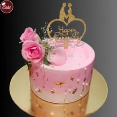 A lovely pink anniversary cake decorated with fresh roses and gold leaf flakes. The heart-shaped topper adds a romantic touch to this beautiful celebration cake.