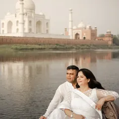 A serene boat ride on the Yamuna river, with the majestic Taj Mahal creating a breathtaking reflection. This is a classic and timeless pre-wedding shot in Agra.