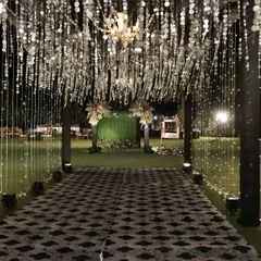 A dramatic entrance for a Sangeet night, featuring a canopy of silver tassels and a patterned walkway. It sets the tone for a high-energy, glamorous event.