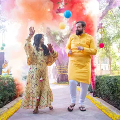 A fun-filled moment from a haldi ceremony, with the couple dancing amidst colorful smoke bombs. I capture the energy and excitement of these celebrations.