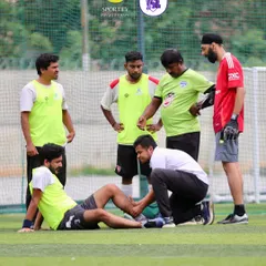 A physio attends to an injured player on the pitch, surrounded by concerned teammates. This shows our commitment to providing immediate care during games.