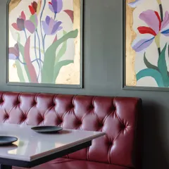A detail of the arched floral panels, where petals are paused in time against a gold foil background. This piece adds a touch of classic elegance to the restaurant's vibrant interior.