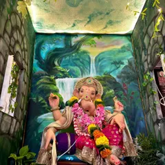 A different angle of the waterfall-themed decoration, showing the painted ceiling that adds to the immersive effect. The hanging vines with fairy lights make the space feel magical and alive.