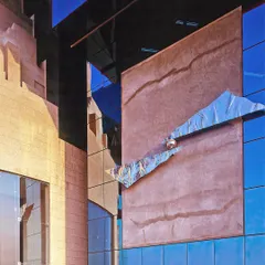 A detail of the UTI Headquarters facade, where solid, rock-like forms meet reflective glass. A metal sculpture appears to float between the panels, representing the balance we sought to achieve between strength and progressiveness.
