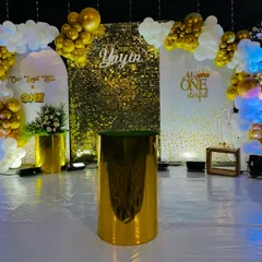 An elegant and glamorous first birthday setup in gold and white. This design features a gold shimmer wall, custom arched panels, and a sophisticated balloon arch, perfect for a "Mr. ONEderful" theme.