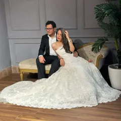 Making pre-wedding shoot dreams come true. This couple looks timeless in a classic black suit and a stunning white lace ball gown with a long train, perfect for creating elegant and romantic portraits.