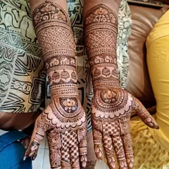 This design for bride Pragna features beautiful bands of traditional patterns, including elephants, jharokhas, and a central lotus motif on the palm.