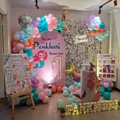 An enchanting mermaid theme for a first birthday. We created an underwater world with a purple and teal color scheme, mermaid tail balloons, and a personalized milestone board for the birthday girl.