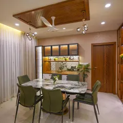 An elegant dining space designed for family gatherings. The marble-topped table is paired with comfortable upholstered chairs, while a custom crockery unit with backlighting provides both storage and a beautiful display.