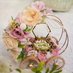 This isn't just a ring platter; it's a centerpiece. Our "Ring on Wheels" carriage, adorned with pastel florals and delicate pearls, makes the ring exchange ceremony truly magical and unforgettable.
