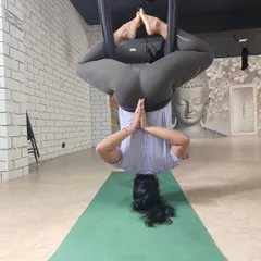 An inverted Baddha Konasana (Bound Angle Pose) in the aerial hammock. This variation allows for a deep hip opening without any pressure on the spine.