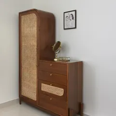 Rattan is the perfect material for airing closets as it allows for ventilation. Here, we designed custom closets integrated with a chest of drawers, providing a complete and functional storage solution for the bedroom.