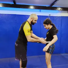The moment of promotion. Tying on a new belt is a physical symbol of the progress and commitment they've made on the mats. It's a big deal.