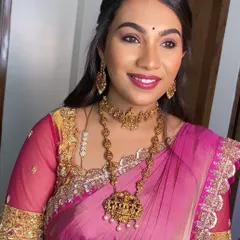 My client Aishwarya looks radiant in this pink and gold ensemble for a family wedding. The blouse features heavy embroidery on the sleeves and neckline, designed to complement her gorgeous temple jewellery. This is a perfect example of a rich, traditional look for wedding festivities.
