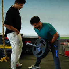 Proper form is everything. Here, I'm guiding a client through a bent-over row, a crucial exercise for building a strong back and improving posture.