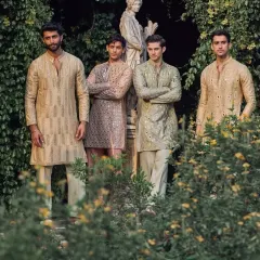 A group of groomsmen wearing my custom mirror-work kurtas in a variety of pastel shades like beige, pink, and sage green. I can create coordinated yet unique looks for your entire wedding party.