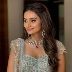A soft and dreamy look for an engagement or sangeet. The gentle waves and half-up style perfectly frame her face, complementing the delicate pastel lehenga.