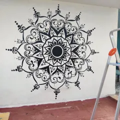 The line work is taking shape. Here you can see the intricate framework of the mandala being carefully hand-painted on the wall. I use a ladder to reach the higher sections, ensuring every line is precise.