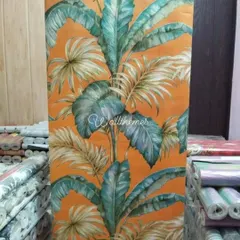 This vibrant tropical leaf wallpaper, shown here unrolled, is perfect for creating a bold and lively accent wall. The bright orange background and lush green foliage bring a touch of nature indoors.