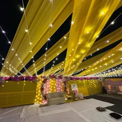 We can turn any space into a celebration zone, even a terrace. Here's a full view of a vibrant Haldi ceremony setup, where we used bright yellow drapes and thousands of fairy lights to create a festive canopy under the night sky.