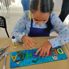 A young artist carefully places embellishments on her personalized nameplate. It's all in the details!