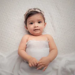 I will always and forever love the simplicity of all-white setups. This beautiful baby girl wrapped in white fabric with a delicate headband looks so pure and angelic.