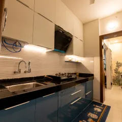 Another angle of the Pune kitchen, showing the glossy finish on the cabinets which reflects light and makes the space feel brighter. The layout is designed for an efficient workflow.
