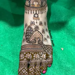 A beautiful foot design featuring peacocks and a representation of the Buddha, creating a serene and spiritual look.