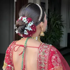 The back of this classic bridal look is just as stunning as the front. Shakshi created this beautiful, neat bun adorned with fresh red and white flowers for a timeless touch.