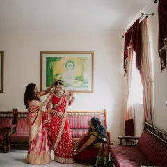 A candid moment of the bride getting ready, with her mother and another family member helping with her final touches. These family interactions are a precious part of the wedding story.