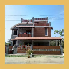 The facade of the Hemavathi and Hareesh residence, featuring a unique curved roofline and a blend of grey stone and red brick for a distinctive look.