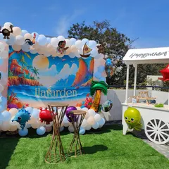 Taking the party outdoors with a vibrant Moana theme. I used a custom printed backdrop of a beach scene, framed by a blue and white balloon garland with character foil balloons. The setup is completed with a cute party cart, perfect for serving treats on a sunny day.