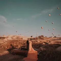 The long trail of the peach gown drapes beautifully over the vintage car, creating a romantic and cinematic feel for this destination pre-wedding shoot.