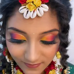 A stunning and colorful eye makeup look for a Haldi ceremony. The sunset-inspired blend of yellow, orange, and pink eyeshadow is playful and perfect for the occasion.