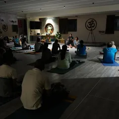 The serene setting of our fusion workshop, combining aerial yoga with sound healing meditation. The low light and focused sound create a perfect environment for deep relaxation and inner peace.