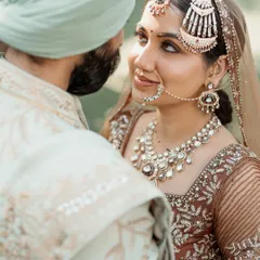A close-up shot capturing the loving gaze between the bride and groom. This intimate portrait highlights the bride's beautiful jewelry and the deep connection they share.