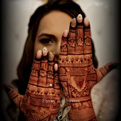 A happy bride peeking through her hands, showcasing the gorgeous after-stain result of my kumkum-jaggery henna. Pure, rich, and absolutely stunning.