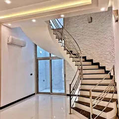 My work seamlessly integrates with your home's architecture. Here, I've added a textured white brick accent wall that complements the modern staircase, adding texture and visual interest to the double-height space.
