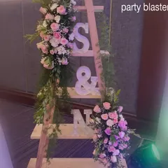 A decorative ladder displaying the couple's initials, adorned with flowers. This is a unique and personal touch we love to add to anniversary celebrations.