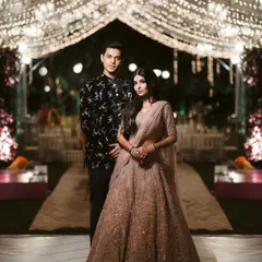 A beautiful couple poses under a canopy of fairy lights at their reception. I love creating these magical, starlit walkways that make for unforgettable photos and an even more memorable evening.