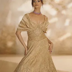 Golden hour, but make it couture. This stunningly embellished A-line gown features a flared bottom and a draped bodice, creating a look of pure elegance in motion.