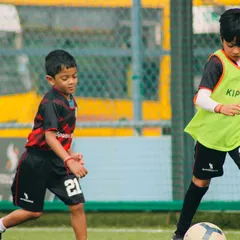 Here you can see two of our young players in a practice match, one focused on defending while the other controls the ball. This is where they learn to apply their skills.