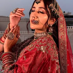 A moment of royal contemplation. This shot highlights the intricate jewelry and the soft, blended makeup that enhances the bride's features for a truly regal feel.