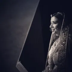 A beautiful black and white profile portrait of a bride. The soft lighting and her gentle smile create a timeless and classic feel.