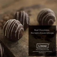 A close-up of our classic chocolate truffles, showcasing the delicate white chocolate drizzle. This image captures the pure richness and texture that comes from using real couverture chocolate.