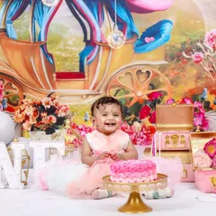 A fairytale first birthday for a little princess. This elaborate setup features a royal carriage backdrop, a pink castle cake, and plenty of sparkle for a magical celebration.